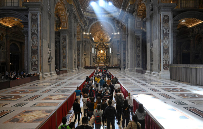 Casi 130.000 fieles católicos han acudido a despedir al papa Francisco 1 a group of people in a large building